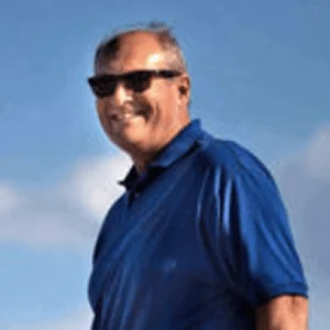 A man on blue shirt with black glasses